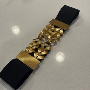 Zara black elastic belt featuring a braided golden metal appliqué.